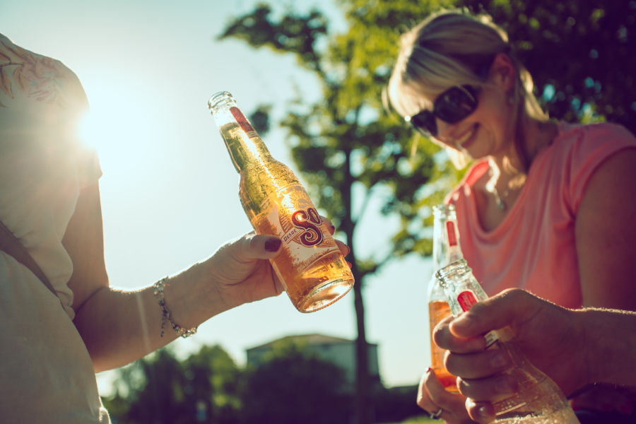 two females drinking beer in the sunshine